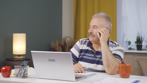 Home-office-worker-old-man-getting-bad-news-on-the-phone.